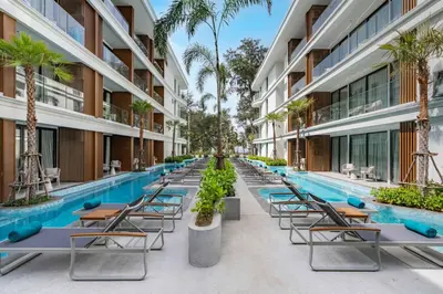an empty pool at a hotel with chairs and palm trees at Studio Apartment by Sunshine Beach in Layan Beach