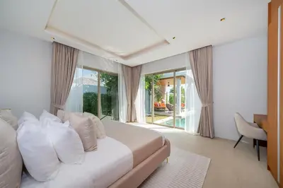 a bedroom with a bed with white pillows and a window at NEW Luxury 4BR Villa with Pool & relaxation zones D07 in Phuket