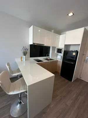 a kitchen with a white counter and a black refrigerator at 2 комнатные апартаменты с одной спальней и кухней-гостиной in Phuket Town