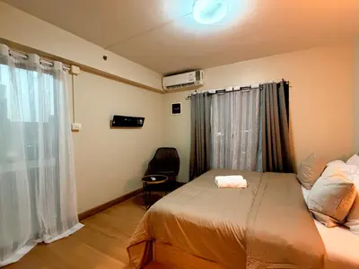 a small bedroom with a bed and a window at 1BR Apartment Suite in the heart of Phuket Town in Ban Lo Long