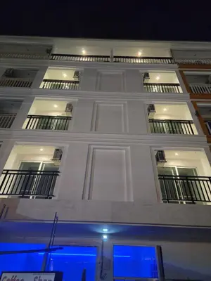 a large white building with windows and a blue at Elite Luxury Apartment Patong in Patong Beach