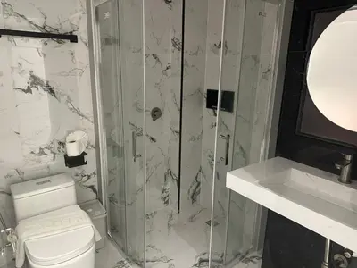 a bathroom with a toilet and a glass shower at Elite Luxury Apartment Patong in Patong Beach
