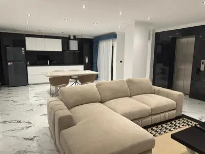 a living room with a couch and a kitchen at Elite Luxury Apartment Patong in Patong Beach