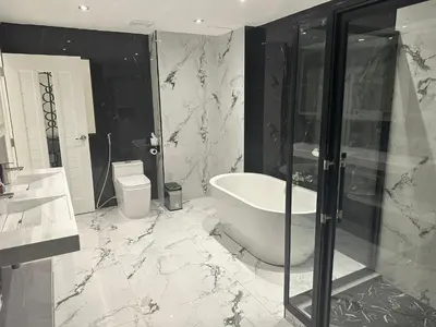 a bathroom with a tub and a shower and a toilet at Elite Luxury Apartment Patong in Patong Beach