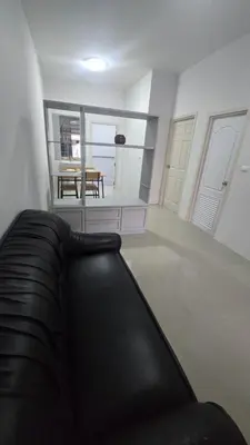 a living room with a black couch and a table at Phuket villa airport in Nai Yang Beach