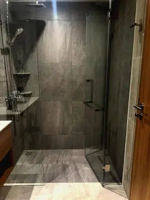 a shower with a glass door in a bathroom at Laguna Beach Residences Seashore by Banyan Living in Phuket