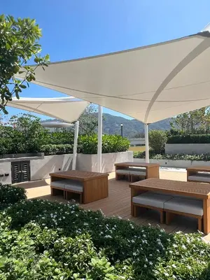 a patio with benches and a white canopy at Laguna Beach Residences Seashore by Banyan Living in Phuket