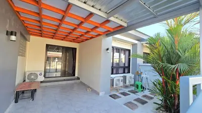 an indoor patio with an orange ceiling and plants at Joyful House Naiyang beach in Thalang