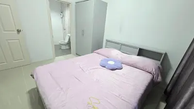 a bed with a purple stuffed animal on top of it at Joyful House Naiyang beach in Thalang