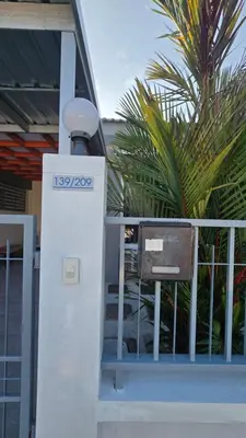 a street light next to a fence with a chair at Joyful House Naiyang beach in Thalang