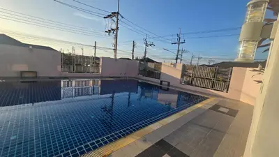 a swimming pool in the middle of a building at Joyful House Naiyang beach in Thalang
