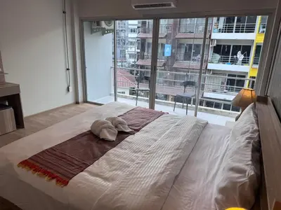a large bed in a room with a large window at Global Hills Hotel in Patong Beach