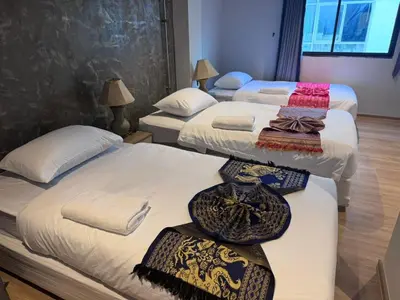 a room with three beds with ties on them at Global Hills Hotel in Patong Beach