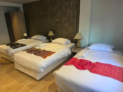 three beds in a hotel room with bows on them at Global Hills Hotel in Patong Beach