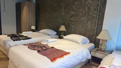 two beds in a hotel room with towels on them at Global Hills Hotel in Patong Beach