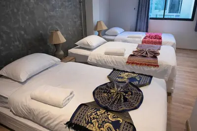 a group of three beds with towels and ties on them at Global Hills Hotel in Patong Beach