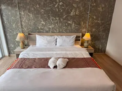 a bedroom with a bed with two towels on it at Global Hills Hotel in Patong Beach