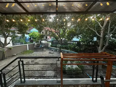 a wooden bench sitting under a canopy with lights at Kamala cozy home in Kamala Beach