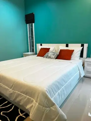 a bedroom with a large white bed with red pillows at Kamala cozy home in Kamala Beach