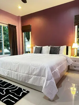 a large white bed in a bedroom with purple walls at Kamala cozy home in Kamala Beach