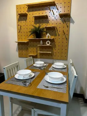 a dining room table with plates and a clock on the wall at Kamala cozy home in Kamala Beach