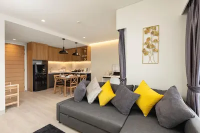 a living room with a gray couch and yellow pillows at Laguna LakeSide Residences by My Home Phuket in Bang Tao Beach