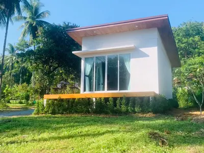 a small house with a window in the grass at GOODNIGHT Hill KOHYAOYAI in Ban Nai Wat