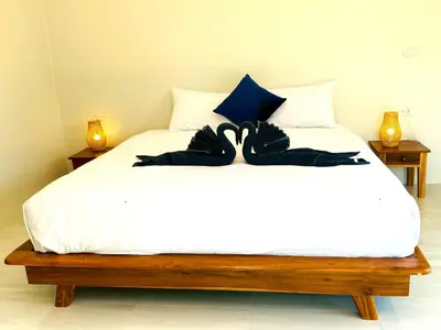 a bedroom with a white bed with black sheets at GOODNIGHT Hill KOHYAOYAI in Ban Nai Wat