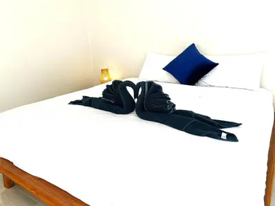 a bed with two black slippers on it at GOODNIGHT Hill KOHYAOYAI in Ban Nai Wat