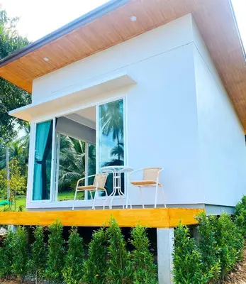 a house with a porch with two chairs and a table at GOODNIGHT Hill KOHYAOYAI in Ban Nai Wat
