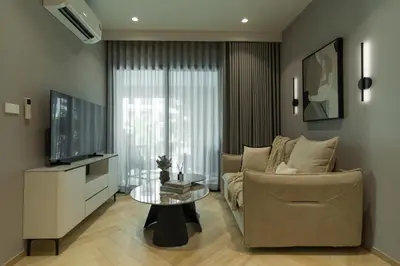 a living room with a couch and a tv and a table at Title Legendary Apartment 800m to Bang Tao Beach in Bang Tao Beach