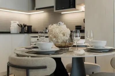 a table with glasses and a vase of flowers on it at Title Legendary Apartment 800m to Bang Tao Beach in Bang Tao Beach