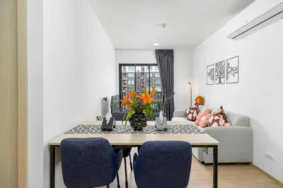 a dining room with a table and blue chairs at C262 Relax 2BR Condo with Pool and Full Gym in Kathu