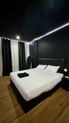 a bedroom with a large white bed with lights on it at Atrium Kathu Hotel in Ban Kathu
