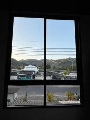 an open window with a view of a parking lot at Atrium Kathu Hotel in Ban Kathu