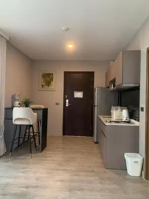 a kitchen with a refrigerator and a table with a stool at Royal Lee The Terminal Phuket in Thalang