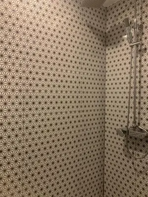 a bathroom with a tiled wall with a shower at Royal Lee The Terminal Phuket in Thalang