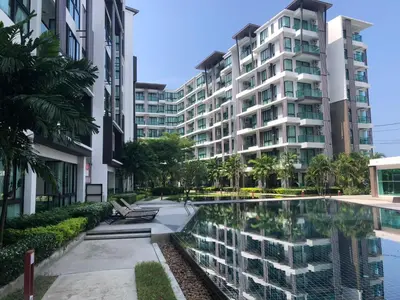 an apartment building with a pool in front of it at Royal Lee The Terminal Phuket in Thalang