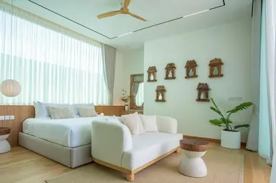 a bedroom with a white bed and a white couch at OASIS Luxury Private Villa in Ban Phru Champa