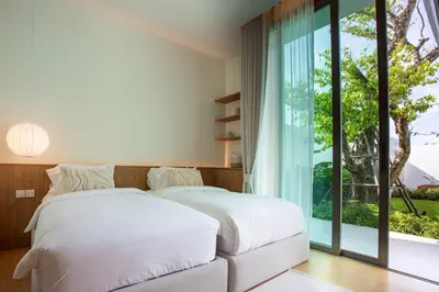 two beds in a bedroom with a large window at OASIS Luxury Private Villa in Ban Phru Champa