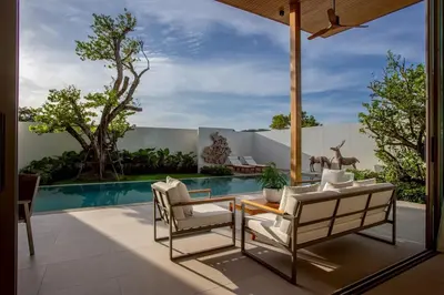 a patio with a table and chairs and a pool at OASIS Luxury Private Villa in Ban Phru Champa