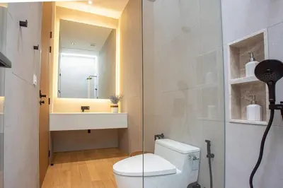 a bathroom with a toilet and a sink and a mirror at OASIS Luxury Private Villa in Ban Phru Champa