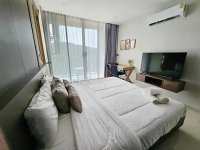a bedroom with a large bed and a television at patong see view condo in Patong Beach