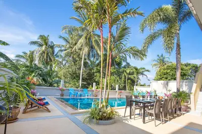 a patio with a table and chairs next to a pool at Large Private Pool 5BR Villa Tony near Promthep Cape in Nai Harn Beach