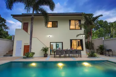 a villa with a swimming pool in front of a house at Large Private Pool 5BR Villa Tony near Promthep Cape in Nai Harn Beach