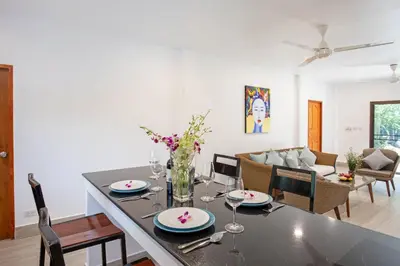a dining room and living room with a table and chairs at Large Private Pool 5BR Villa Tony near Promthep Cape in Nai Harn Beach