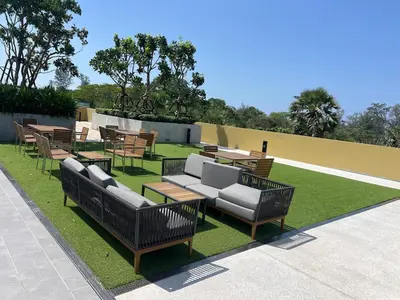 a group of benches and tables on a lawn at 3 bedrooms in Laguna, Bangtao Beach 5 min walk in Bang Tao Beach