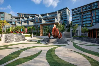a park in front of a building with a sculpture at Ocean Breeze 1-BR apartment, Sea View, Surin beach in Ban Lum Fuang
