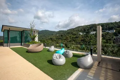 a group of white vases sitting on the grass at Ocean Breeze 1-BR apartment, Sea View, Surin beach in Ban Lum Fuang