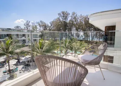 two chairs on a balcony with a view of a resort at Kora 267 3BR Condo with Pool View in Phuket Town